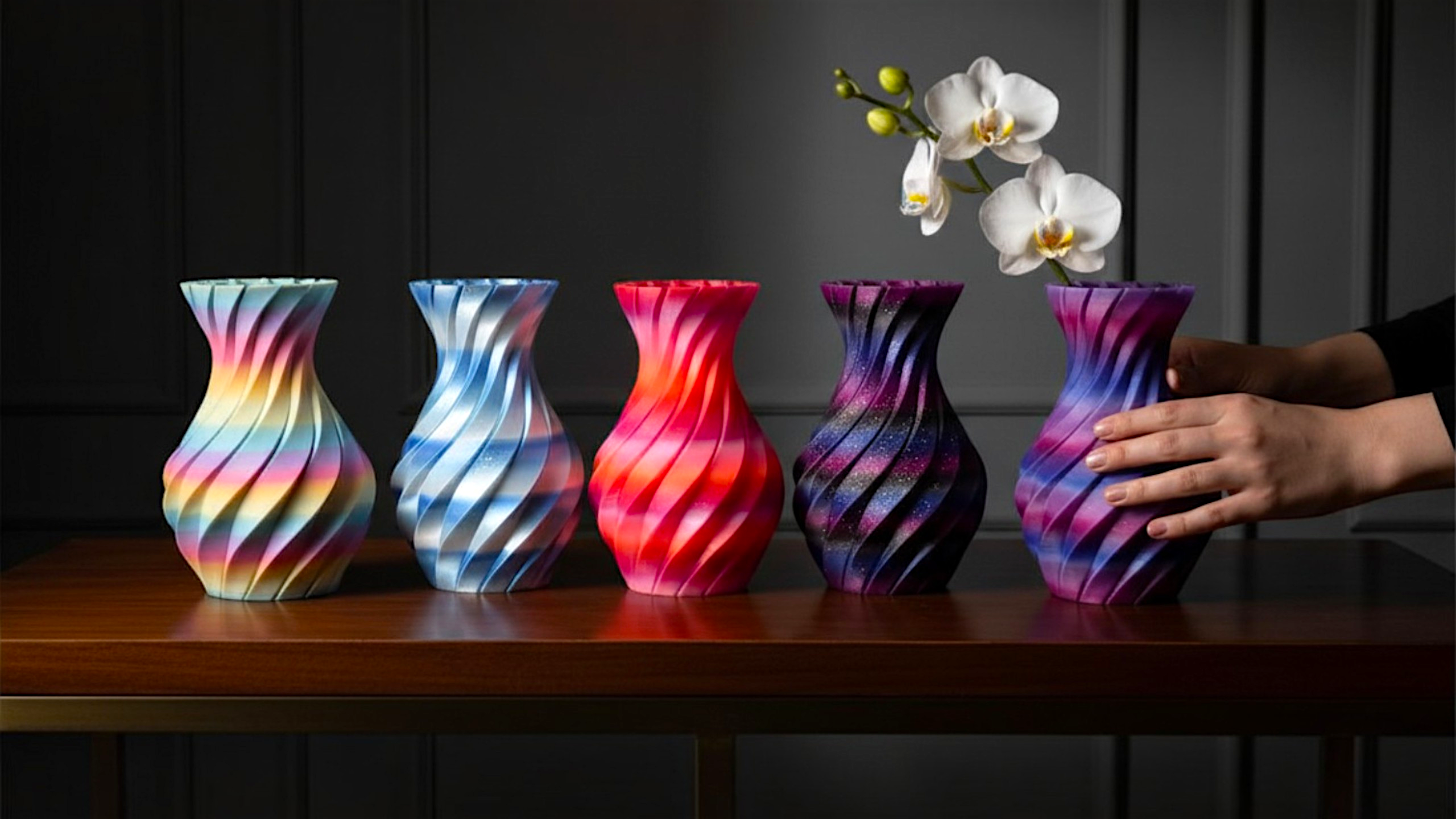 JT-PRINT-SERVICE Twisting Pillars vases in five gradient colorways with spiral ribbed designs on a wooden table.